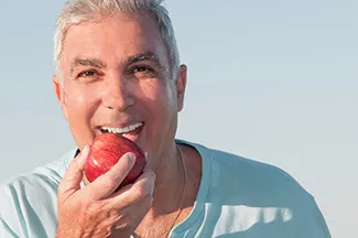 A man about to bite into an apple