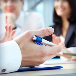 A doctor holding a pen in their hand while consulting with patients